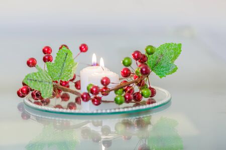 Interior with candles on a mirror plate with decorative flowersの写真素材