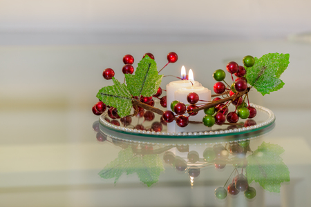 Interior with candles on a mirror plate with decorative flowersの写真素材