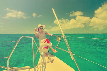 Beautiful woman relaxing on saiboat in middle of the caribbean seaの写真素材