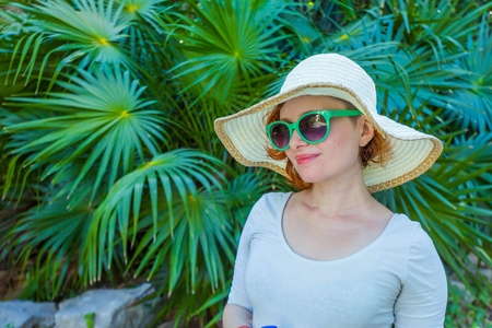 Young girl in the park in green glassesの写真素材