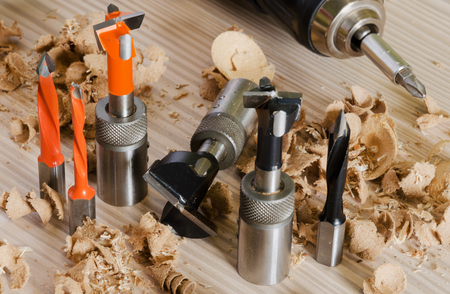 Machine tool cutters and drill bits in the sawdust on wood backgroundの写真素材