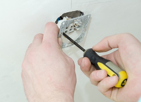 construction work, installation of the electrical panel in the wall, hand electrician closeupの写真素材