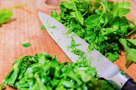 chopped herbs on cutting board with a knifeの写真素材