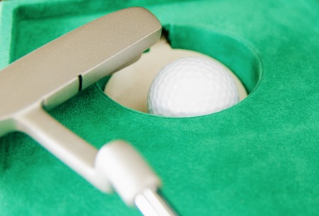 indoor mini golf, ball pocket and putter on green clothの写真素材