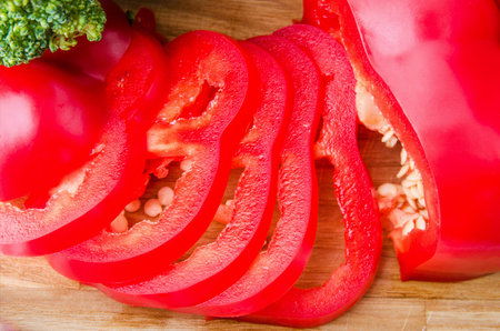 broccoli and tomato and red pepper on cutting board isolated on white