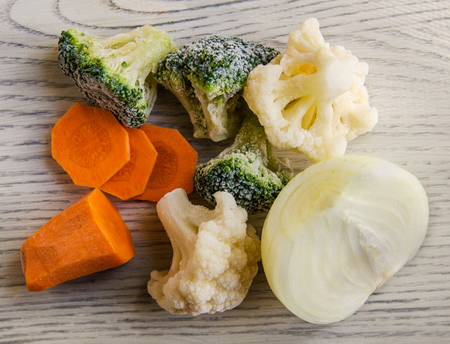 broccoli, cauliflower and other frozen vegetables on a wooden backgroundの写真素材