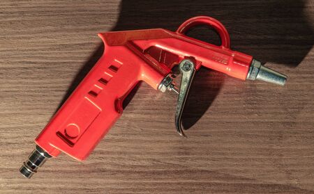 orange air gun close-up on wooden backgroundの写真素材