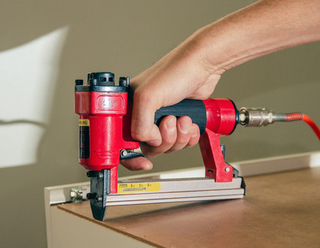 Stapler gun protective gloves on wood board construction concept.の写真素材