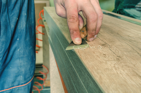 The master processes the edge of the furniture with a working knifeの写真素材