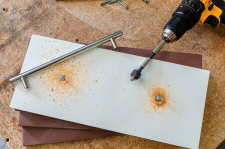 Assembling furniture, installing furniture decorative handles on the furniture facadeの写真素材