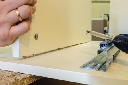 Furniture fittings, wooden dowels, fastener connection on chipboard workpieces, close-up