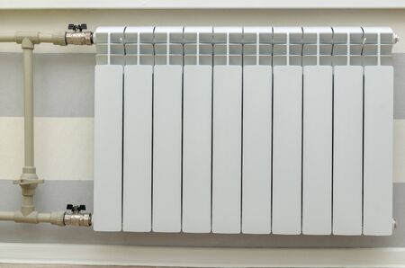 White aluminum radiator on the wall in the living room, close-upの写真素材