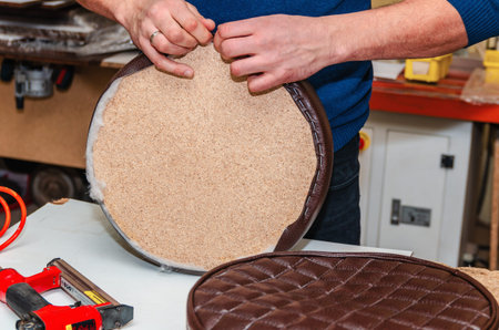 Seat upholstery in a furniture workshop, eco-leather cover, close-up