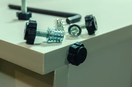 Assembling furniture, installing guides for drawers on furniture panels close-up.