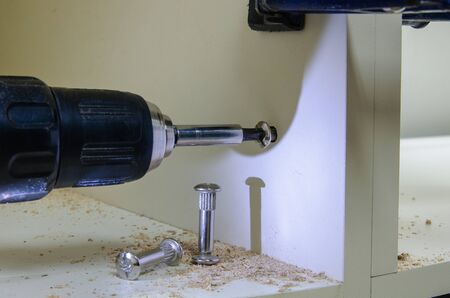 Assembling furniture, installing guides for drawers on furniture panels close-up.の写真素材