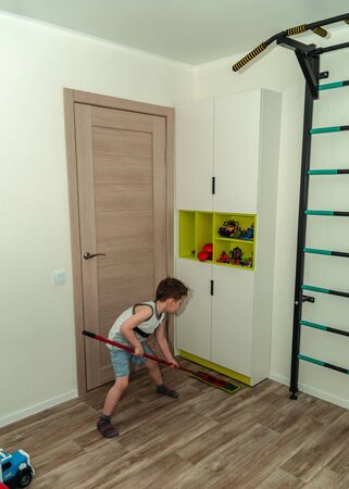 Little boy cleans his room, mops floors, duties of a childの写真素材