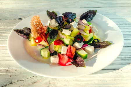 summer vegetable salad on a white dish on a wooden backgroundの写真素材