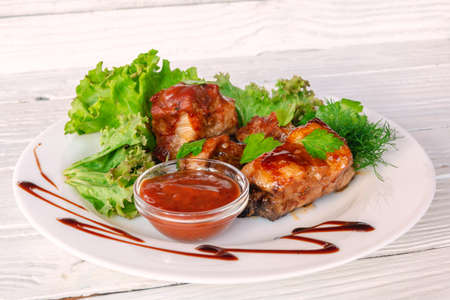 Grilled fried meat on a plate with salad and herbs, shish kebab in tomato sauceの写真素材