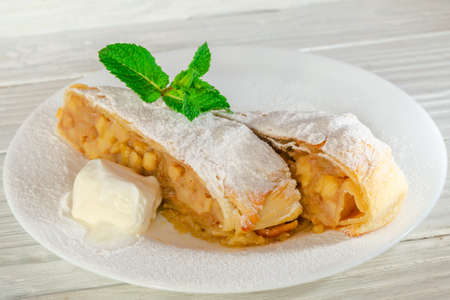 Hot fruit strudel with apple spices and a slice of butterの写真素材