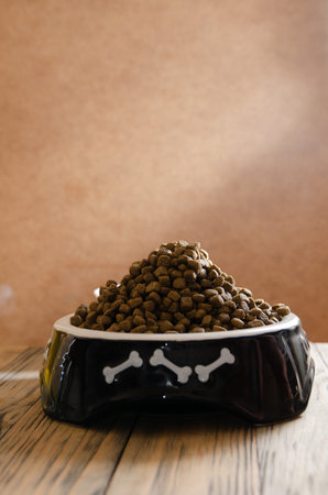 Full bowl of dog food close up on wooden backgroundの写真素材