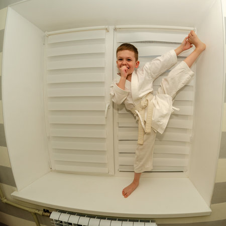 Little boy of preschool age does morning exercises on a home horizontal barの写真素材