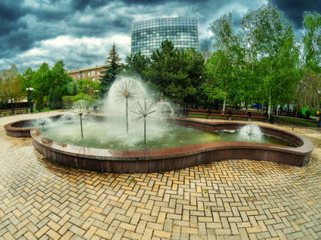Cloudy weather on a summer day in the city park near the fountain.の写真素材