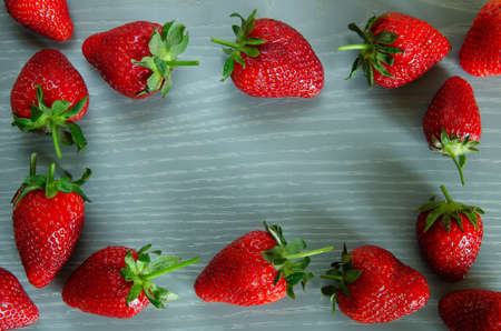 A lot of red ripe strawberry berry on a gray wooden background.の写真素材