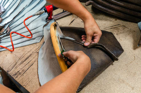 manufacture of upholstered furniture, upholstery of a furniture element with a pneumatic stapler, close-upの写真素材