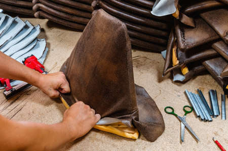 manufacture of upholstered furniture, upholstery of a furniture element with a pneumatic stapler, close-upの写真素材
