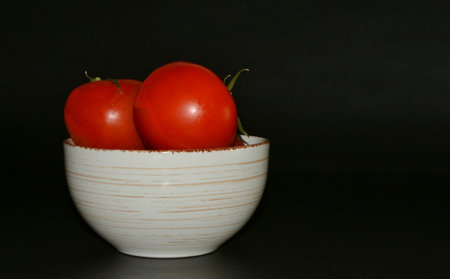 Fresh Tomatoes with water drops on slate plateの写真素材
