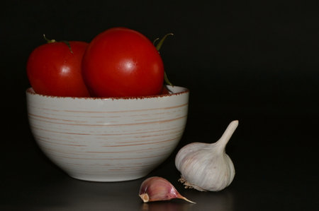 Fresh Tomatoes with water drops on slate plate and gurlicの写真素材