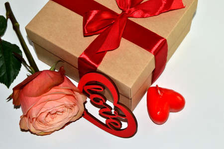 Gift box, rose flower and decorative heart on a white backgroundの写真素材