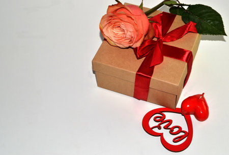 Gift box, rose flower and decorative heart on a white backgroundの写真素材