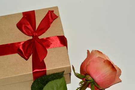 gift box with red ribbon and pink rose isolated on white backgroundの写真素材