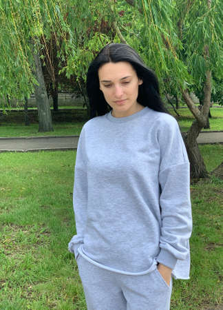 Pretty brunette woman in gray suit posing in the parkの写真素材