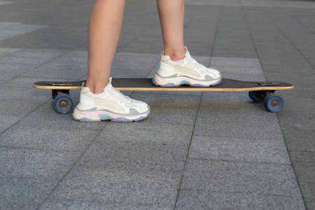 Close up of woman skateboarder legs skateboarding outdoorの写真素材
