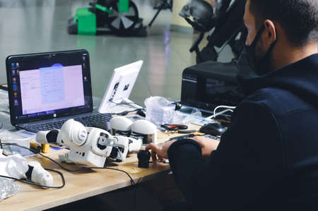 man repairing a robot. Close up of a man fixing a broken little robotの写真素材