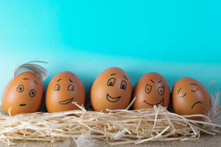 Brown easter eggs with funny faces on blue background