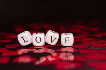 The word LOVE from wooden cubes on a dark wood. St. Valentine's day backgroundの写真素材