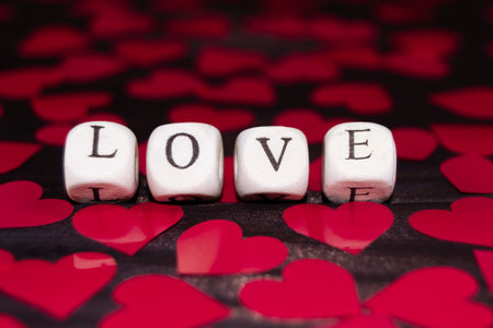 The word LOVE from wooden cubes on a dark wood. St. Valentine's day backgroundの写真素材
