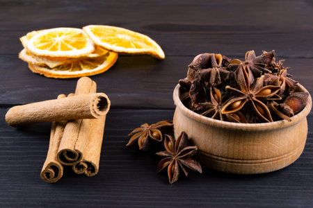 Dried orange slice, cinnamon sticks and anise on wooden background. Traditional christmas...