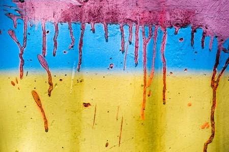Ukrainian flag painted on wall. Yellow blue wall texture background. Grunge yellow blue wall background with red blood paint. abstract grunge background.の写真素材