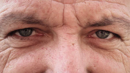Beautiful blue man eyes close up. Portrait of senior man with blue eyes and wrinklesの写真素材