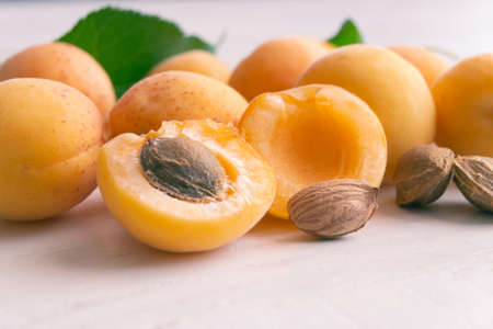 Apricots and kernels on a white wooden background. Apricot seeds.の写真素材