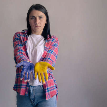 Portrait of beautiful Ukrainian woman with painted hands. Blue and yellow as a symbol of Ukraine. copy spaceの写真素材