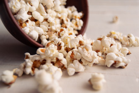 A bowl of popcorn on a white wooden surfaceの写真素材