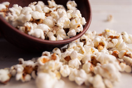 Bowl with popcorn on a white wooden table.の写真素材
