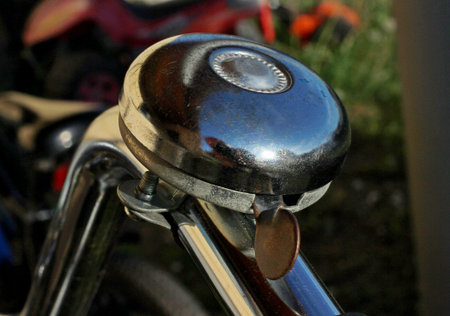 old scratched bicycle bell on the steering wheel close-up