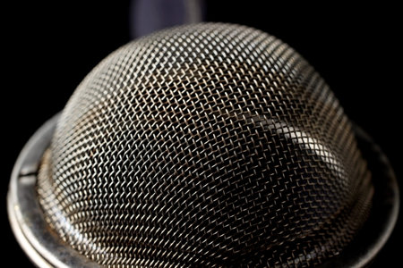 metal strainer for brewing loose tea close-up on a black background