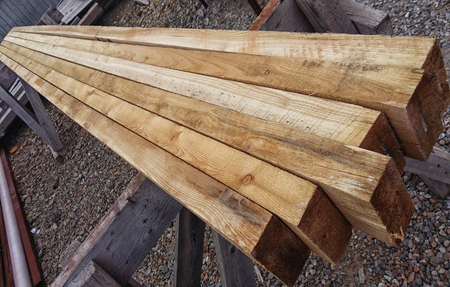 Edged boards of natural wood lie in a row unpolished with burrsの写真素材